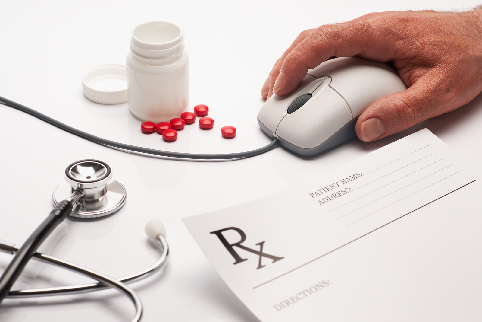 Prescription medicine and pharmacist hand on computer mouse